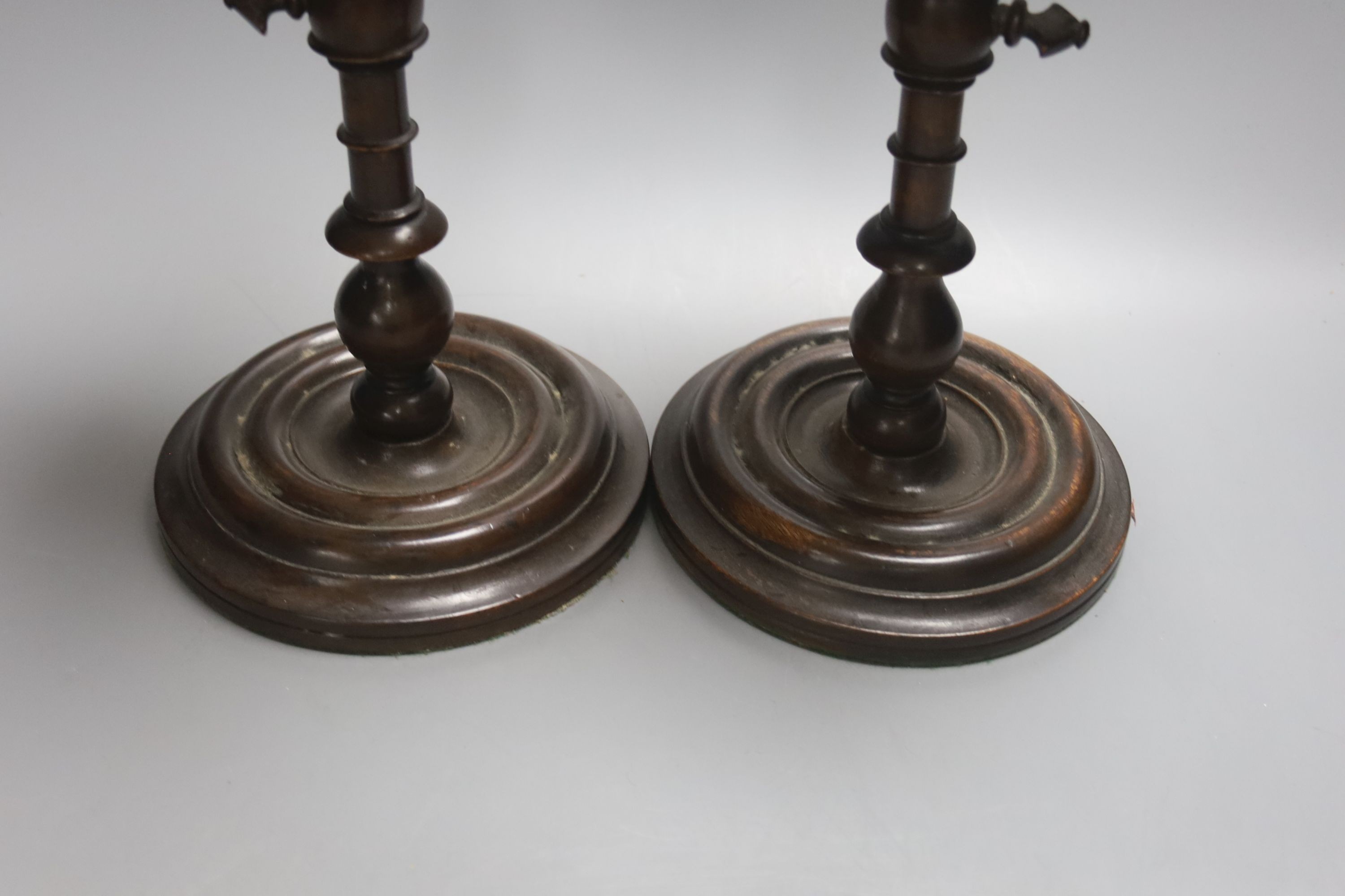 A pair of Georgian style stained beech adjustable candle stands, height 24cm
